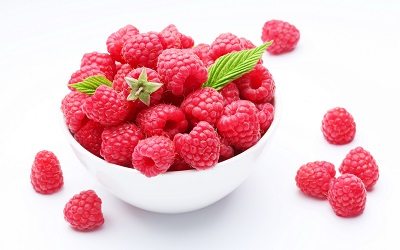 Crockery with  beautiful tempting raspberries Isolated on white background.
